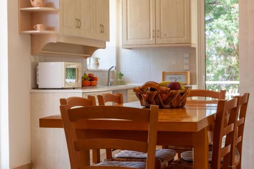 a kitchen with a table with a bowl of fruit on it at VillaEvaNafplion in Paralía Iríon