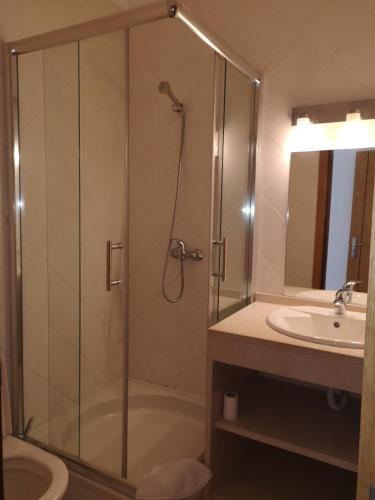 a bathroom with a shower and a sink at Mare Viva Beach Apartment in Quarteira