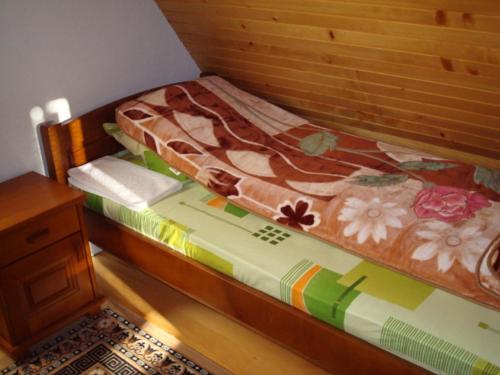 a small bed with a wooden headboard and a wooden table at Rooms and Bungalows Sreten Žugić in Žabljak