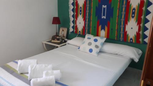 una camera da letto con un letto bianco e una parete colorata di Cortijo la Dehesa del Trabuco a Villanueva del Trabuco