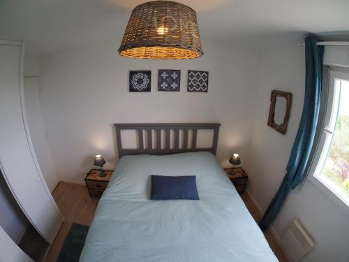 a bedroom with a bed with a blue pillow on it at Cap Bleu in Blonville-sur-Mer