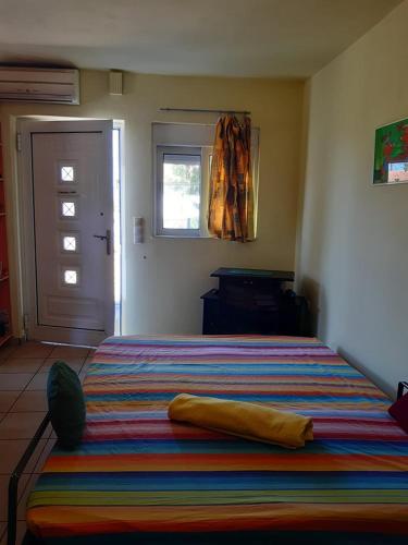 a bedroom with a bed with a colorful blanket on it at Dina in Palaia Fokaia
