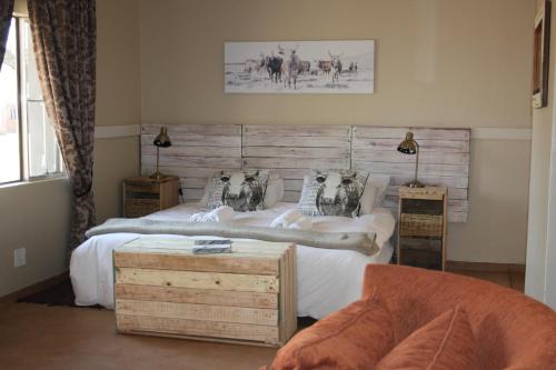 a bedroom with two twin beds and a couch at Out Of Nature Country Lodge in Windhoek