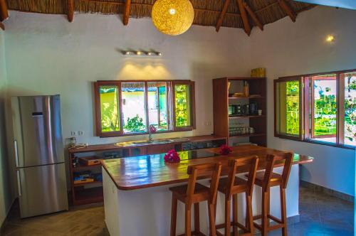 a kitchen with a wooden table and some windows at Vilancool Beach Resort in Vilanculos