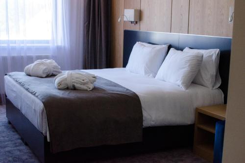 a hotel room with a bed with towels on it at AZZA Hotel in Jesenice
