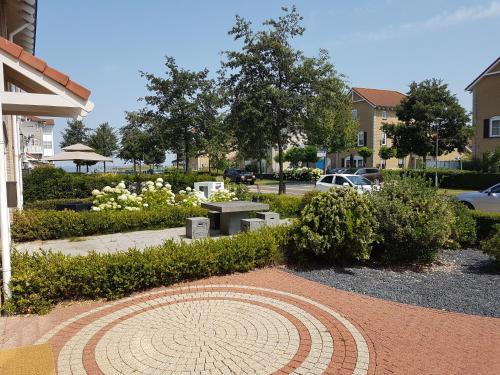 ウェーメルディンゲにあるMiddensluis 7のベンチとテーブルと茂みのある公園