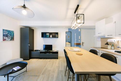 une cuisine et un salon avec une table et des chaises dans l'établissement Appartistic - Appartement des artistes, à Nantes