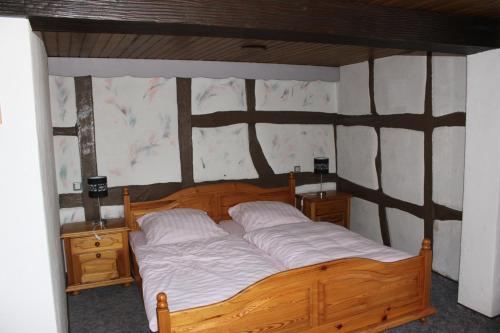 a bedroom with a wooden bed and two night stands at Eulenburg in Rülzheim