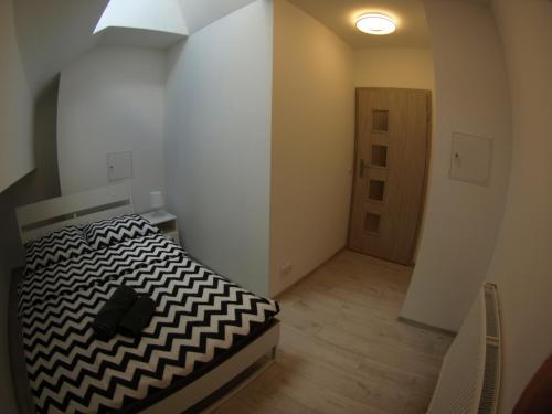- une chambre avec un lit noir et blanc et une porte dans l'établissement Bulwary Apartments, à Szczecin