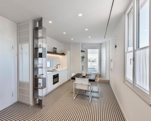 - une cuisine blanche avec une table et une chaise dans l'établissement Attico sul Porto Antico, à Monopoli