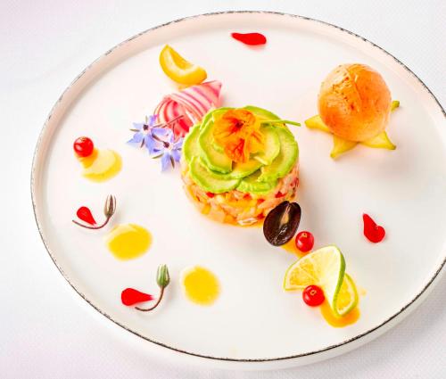 a white plate with a sandwich with vegetables and fruit at Le Bailliage Hôtel & Spa in Salers