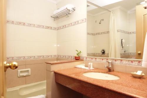 a bathroom with a sink and a shower and a tub at Abad Atrium in Cochin