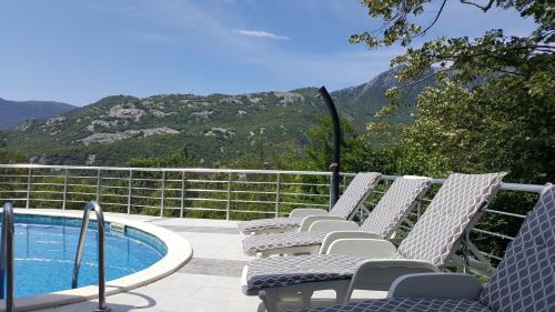 a group of chairs sitting next to a swimming pool at Yokana Villa & Pool in Virpazar