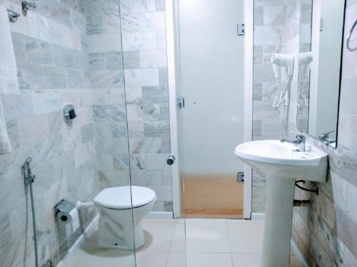 y baño con aseo, lavabo y ducha. en Hotel Dan Inn Express Porto Alegre - 200 metros do Complexo Hospitalar Santa Casa e UFRGS, en Porto Alegre