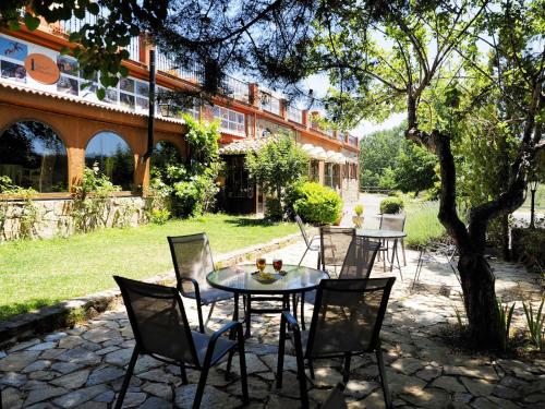 a patio with tables and chairs and a building at Hospedium Hostal Almanzor in Navarredonda de Gredos