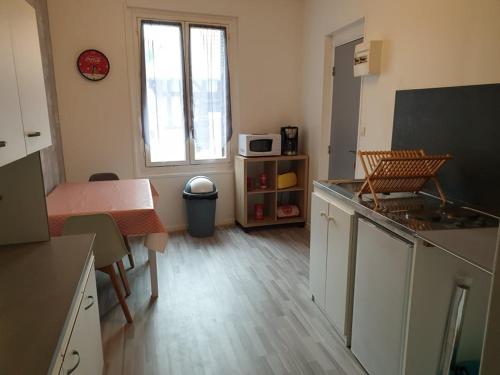 Cette chambre comprend une cuisine équipée d'une table et d'un four micro-ondes. dans l'établissement appartement tiago, au Tréport