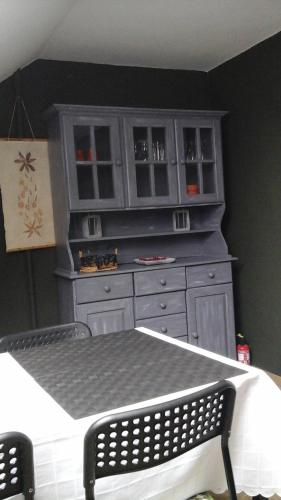 a dresser in a room with a table and a chair at en gaume séjour au calme in Jamoigne