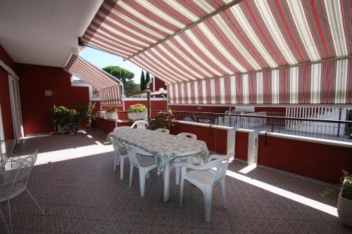 a patio with a table and chairs on a balcony at Villa della Tartaruga in Casal Palocco