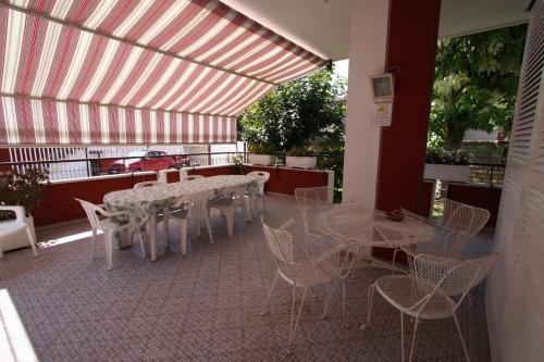 a room with tables and chairs on a patio at Villa della Tartaruga in Casal Palocco