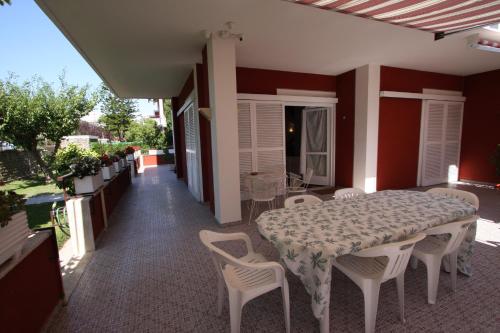 a table and chairs on a patio with a table and a table and chairs at Villa della Tartaruga in Casal Palocco
