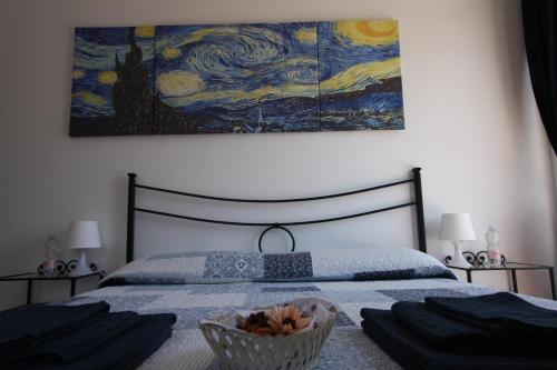 a bedroom with a bed with a painting on the wall at Villa della Tartaruga in Casal Palocco