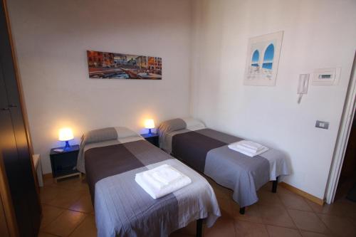 two beds in a room with two lights on them at Villa della Tartaruga in Casal Palocco