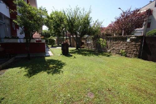a yard with trees and a brick wall at Villa della Tartaruga in Casal Palocco