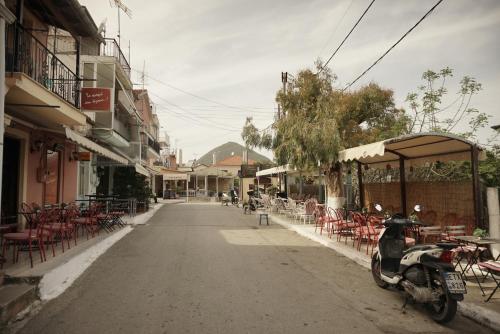 a scooter parked on a street with tables and chairs at J&B Countryside Life - Just for two in Ágios Matthaíos