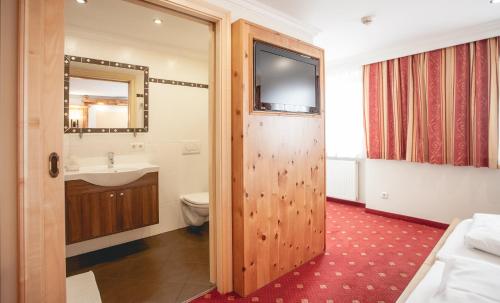 a bathroom with a wooden door and a sink and a toilet at Gasthof Schmalzerhof in Weer
