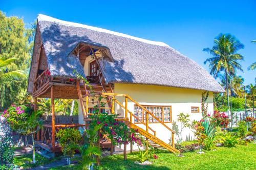a house with a thatched roof and a staircase at Vilancool Beach Resort in Vilanculos