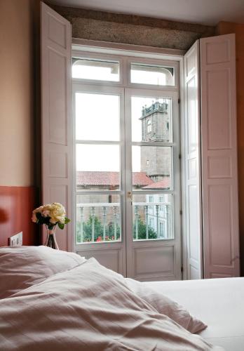 a bedroom with a bed and a window with a view at Hotel Montes in Santiago de Compostela