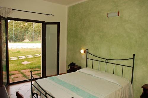 a bedroom with a bed and a large window at La Fattoria in Castelsardo