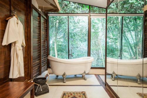 a bathroom with a tub and a large window at Galalima Glamping in Tabanan