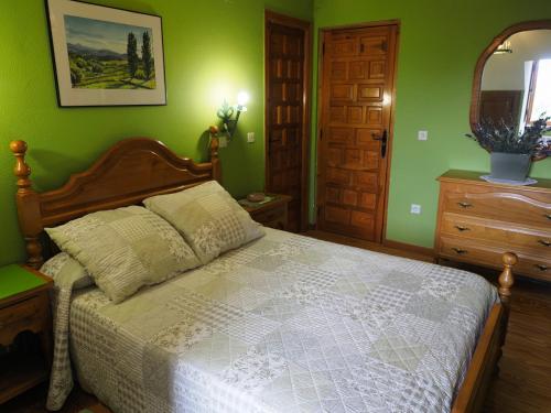 a bedroom with a bed and a dresser and a mirror at Hospedium Hostal Almanzor in Navarredonda de Gredos