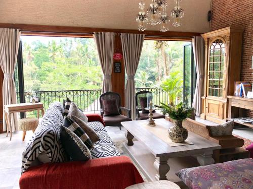 a living room with a couch and a table at Puri Kasih Gottlieb in Ubud