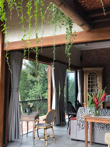 a patio with chairs and tables on a porch at Puri Kasih Gottlieb in Ubud