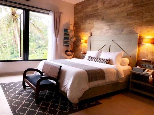a bedroom with a large bed and a window at Puri Kasih Gottlieb in Ubud