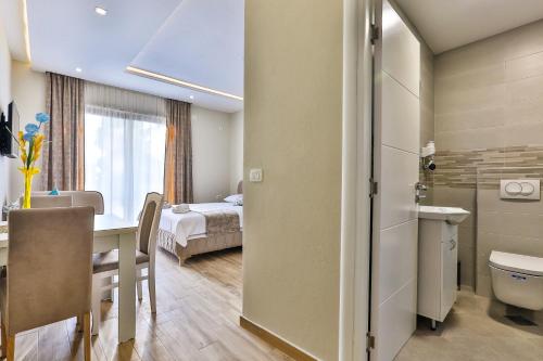 a room with a dining table and a bathroom at Apolon Apart in Bar, Susanj