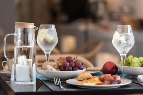 a table with two wine glasses and a plate of food at Marvarit Suites in Mesaria