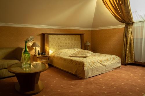 a bedroom with a bed and a table and a couch at Diplomat Club Hotel in Chişinău