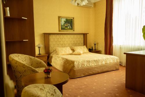 a hotel room with a bed and a chair at Diplomat Club Hotel in Chişinău