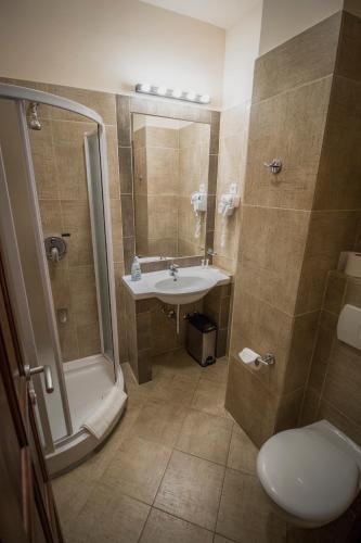 a bathroom with a shower and a sink and a toilet at Renegade Hotel in Siófok