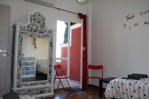 a mirror in a room with a bed and a red chair at Villa della Tartaruga in Casal Palocco