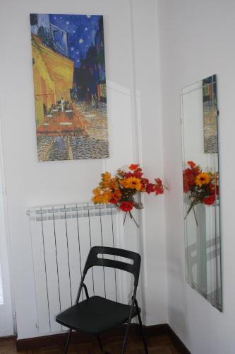 a chair in a room with a painting and flowers at Villa della Tartaruga in Casal Palocco