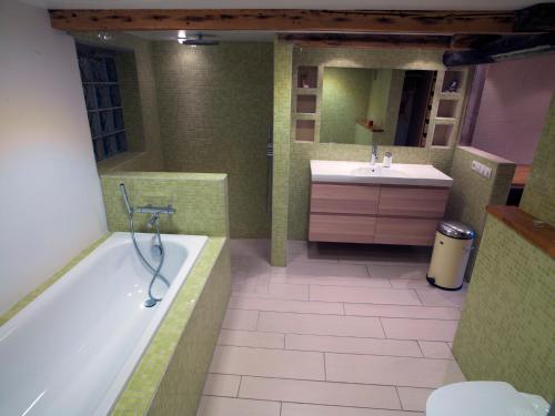 a bathroom with a tub and a sink and a mirror at Town House close to Center in Reykjavík