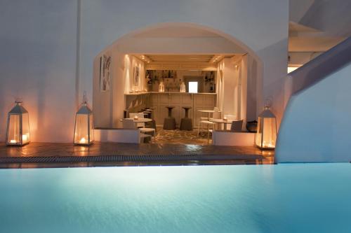 a room with a swimming pool with lights on the floor at Regina Mare-Adults Only Hotel in Imerovigli