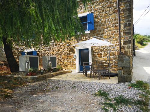 a stone building with a table and an umbrella at Olivia in Šmarje