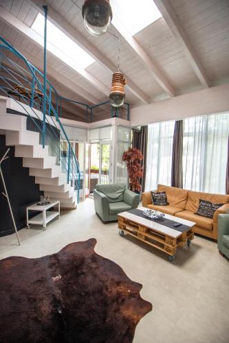 a living room with a couch and a staircase at Renegade Hotel in Siófok