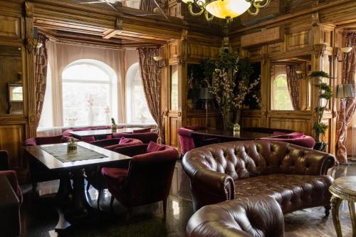 a restaurant with leather furniture and a table and chairs at Diplomat Club Hotel in Chişinău