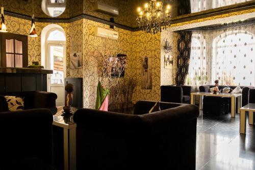 a room with chairs and tables and a chandelier at Diplomat Club Hotel in Chişinău